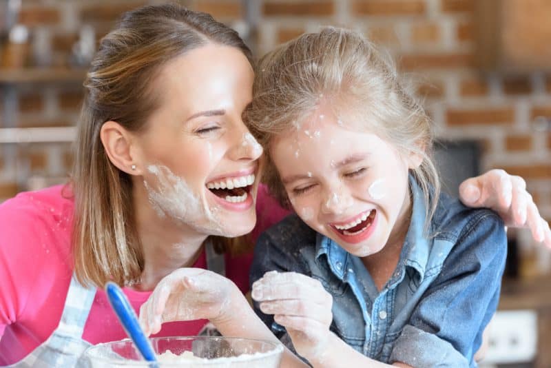 mother and daughter laughing during a funny cooking lesson