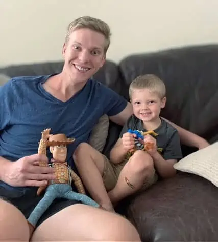 uncle and nephew with their Woody dolls watching toy story