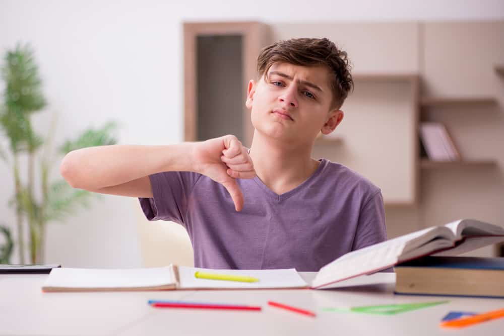 A student who hates to write is pointing his thumb down